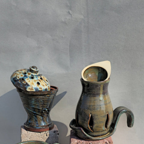 Two ceramic pots with unique designs on a gray background
