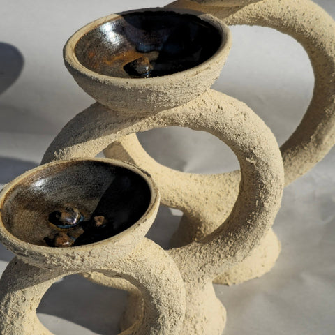 Ceramic cat tree with three round platforms on a white background