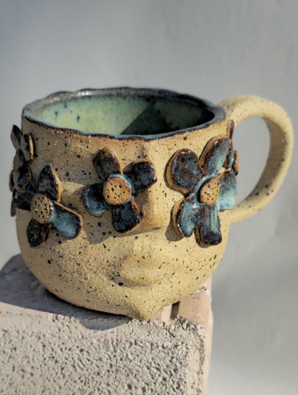 Ceramic mug with floral designs on a neutral background