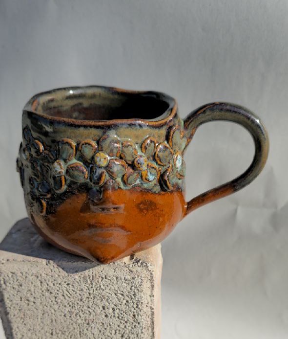 Ceramic mug with textured surface on a gray background